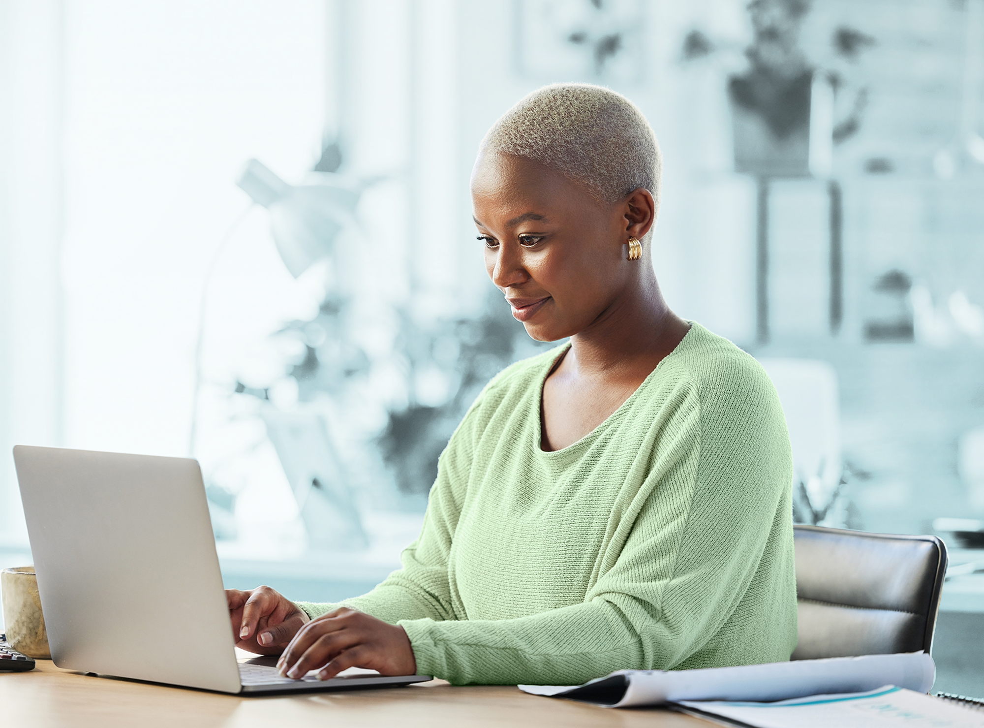 Woman engaged in online learning on her laptop at a desk, representing professional growth and development.